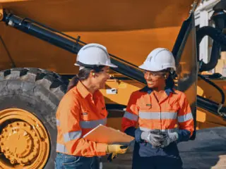 Image of two women in front of large truck