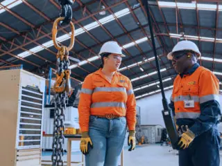 Image of two people working inside an industrial shed