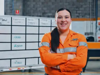 Image of a woman smiling in front of a whiteboard